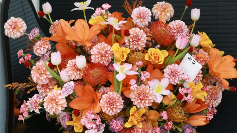 Stunning bouquet featuring lilies, daisies, and roses in a black vase.
