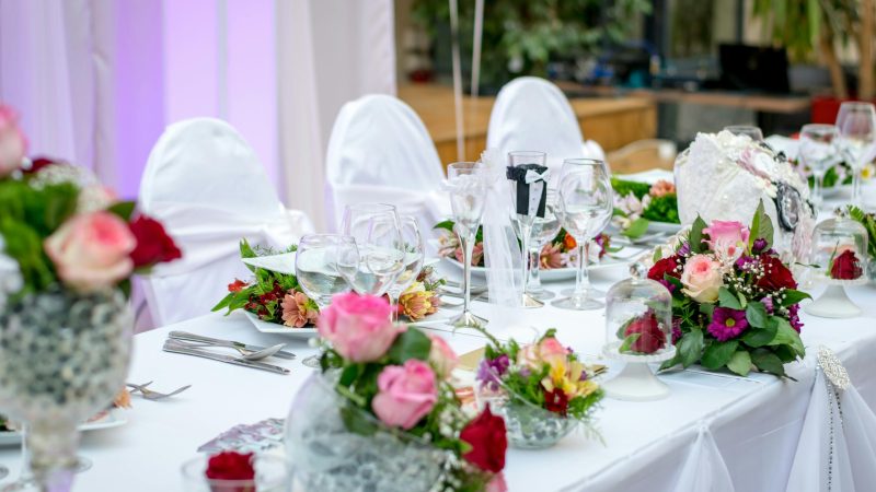 Beautifully decorated wedding table setting with floral arrangements and wine glasses, creating an elegant atmosphere.